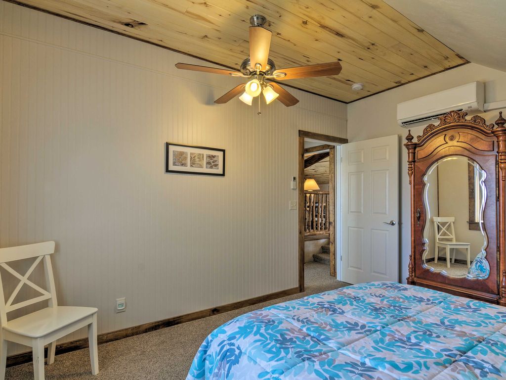 Sunrise Hollow's first bedroom features an elegant wardrobe, comfy queen bed, private climate control, and panoramic views of Bryce Canyon in the distance.